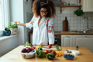 Black woman cooking vegetables in her kiitchen