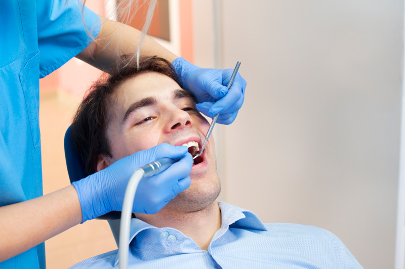 A man receiving a dental cleaning.