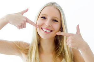 Woman smiling and pointing to her teeth